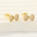 Golden bow stud earrings with sparkling cubic zirconia pavé finish on white display - Bowknot Design (ER0848-A)