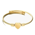 Macro-opname van gouden kabelarmband met hartvormige hanger en schroefmotief kralen - Goud