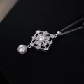 Elegante collana in argento con ciondolo a fiore in zircone e perle bianche su sfondo nero - Argento