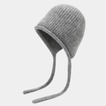 Macro shot of grey knitted beanie with ribbed texture and hanging tassels - One Size / Gray