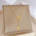 Dettaglio della collana a Y dorata con luna e stella su cuscino di raso e seta morbida - Acciaio al titanio / Oro