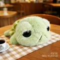 Cute green sea turtle plush toy with big eyes in a cozy cafe setting on a wooden table - 23cm (0.1kg)
