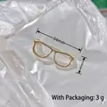 Golden eyeglass shaped brooch pin with rhinestones measuring 34mm by 10mm size - Gold Glasses