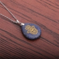 Detailansicht des Hamsa-Hand-Symbols auf blauem Steinhänger mit silberner Kette - Blauer Punkt Jaspis