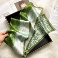Silk scarf with green and white oil painting pattern in a black gift box on fur rug - Oil Painting Prairie