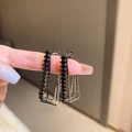 Makroaufnahme von geometrischen rechteckigen dunklen Metallohrringen mit schwarzen Kristallen - Silbernadel-Silberne geometrische Ohrringe (Schwarzer Zirkonia)