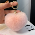 Detailed view of a soft pink heart-shaped faux fur keychain with a gold metal ring - Light Pink