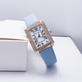 Dettaglio ravvicinato di un orologio quadrato in oro rosa con strass e cinturino in pelle blu - Blu
