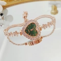 Detailed macro view of heart-shaped rose gold dial with green face and crystal accents - Rose Gold Green