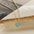 Golden heart pendant necklace with turquoise stones shown in a professional macro shot - Turquoise Heart