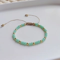 Gros plan de perles de cristal vert menthe et d'entretoises dorées sur bracelet tressé - Perles de Cristal Facettées Vert Menthe (SJS220012B)