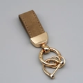 Brown suede leather car keychain with gold hardware and anti-lost rings on gray background - Short Style / Coffee/Gold