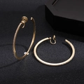 Nahaufnahme goldener Clip-Ohrringe mit glitzernden Kristallen auf dunklem Hintergrund - Clip-Ohrringe / 5cm / Gold