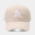 Vista detallada de gorra de lana sherpa beige con letra A bordada en color blanco - Ajustable / Beige