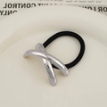 Black elastic hair tie with silver X-shaped metal charm on a ceramic plate decor - X-Shape Silver