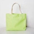 Detail shot of a light green canvas tote bag with sturdy beige woven handles - Open Top / Green