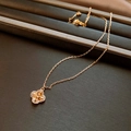 Dettaglio della collana a quadrifoglio in oro rosa con zirconi su un portagioie - Quadrifoglio Intrecciato Oro Rosa / Oro rosa