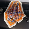 Elegant orange paisley silk square scarf with floral print draped over a black sofa - Small Square Scarf 87 / 65
