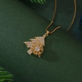 Collier sapin de Noël et flocon doré avec zircons sur fond festif de branches de pin - Sapin de Noël