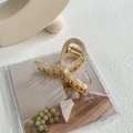 Macro shot of an elegant beige marble acetate and gold metal hair claw clip detail - Rice Green - Gold Clip