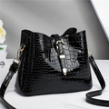 Elegant black crocodile pattern tote bag with gold hardware and adjustable strap on marble - Black