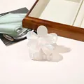 Macro shot of white iridescent flower hair claw clip with pearl finish on wooden tray - PVC 7cm Flower - Iridescent Beige