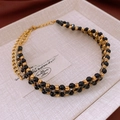Dettaglio collana vintage con perle nere e accenti metallici quadrati dorati - Collana-Nero