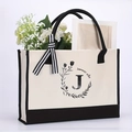 Beige cotton canvas tote bag with black base, letter J print, and striped ribbon bow - Letter-J