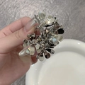Detailansicht einer silbernen Blumen-Haarklammer aus Metall mit glänzendem Finish - Silber