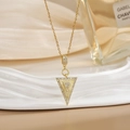 Macro detail of a V-shaped zircon pendant with micro-pave setting on a gold chain - Gold Inverted Triangle Zirconia Style (XL0474)