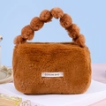 Brown plush cosmetic bag with a soft fuzzy ball handle and a minimalist white label - Dark Coffee