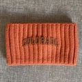 Detail des grob gestrickten Stirnbands in Orange mit Colorado-Logo-Aufnäher - Orangerot