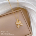 Dettaglio di una collana in titanio dorato con ciondolo a forma di X in zirconi brillanti - Catena in Acciaio al Titanio + Pendente in Rame con Micro-pavè / Pendente a Farfalla in Zirconia a Forma di T (F542) / Oro
