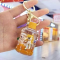 Detalle de primer plano de un dije de Shiba Inu en botella con líquido naranja - Llavero+Forma de Botella D1-1 / Cubo