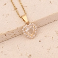 Close-up of a gold heart pendant with a large central crystal and micro-pave cubic zirconia - White Necklace