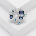 Eleganter silberner Herz-Brosche mit blauen Steinen und Perle auf weißen Geometrien - Blau