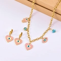Detail of pink enamel heart and evil eye charms on golden stainless steel jewelry set - Necklace + Earrings