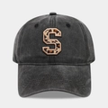 Close-up detail of a vintage black cotton baseball cap with a leopard print S patch - Letter S
