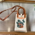 Detailed knit texture of a mini pumpkin crossbody bag with leather handles on glass - Beige Pumpkin - Phone Bag