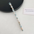 Vue détaillée du pic à cheveux en acétate torsadé avec motif marbré bleu élégant - Forme Torsadée / Marble