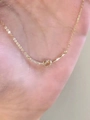 Detailed close-up of golden S925 sterling silver bow knot necklace with sparkling diamonds - 925 Silver / Gold