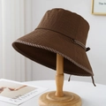 Dettaglio del cappello da sole marrone scuro con nastro a righe e fiocco sul retro - M / Marrone