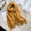 Morbida sciarpa gialla in simil-cashmere con frange stesa su un tappeto di peluche con borsa - Giallo Zenzero