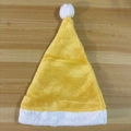 Classic yellow plush Christmas hat with white faux fur trim on a rustic wooden background - Yellow