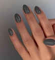 Detalle de uñas postizas almendradas gris oscuro mate en la mano con acabado de color liso - Estilo Ovalado Mate Gris Oscuro (CW527) / 24 Piezas/Juego