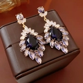 Detailed close-up of vintage purple teardrop earrings with crystals on a leather box - 70# Silver Pin-Gold-Purple