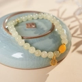 Primer plano de pulsera de cuentas de jade retro con dije de ámbar y colgante Fu dorado - Pulsera de Jade Hetian Cera de Abeja (Caja de Regalo Exquisita)