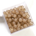 Close-up of polished translucent brown and beige apple-shaped beads for DIY jewelry making - Dark Coffee Apple Bead