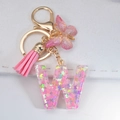 Pink resin letter W keychain with butterfly sequins, tassel and gold-tone lobster clasp - Letter W