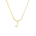 Macro detail of golden letter J pendant with shiny pavé cubic zirconia on snake chain - Letter J